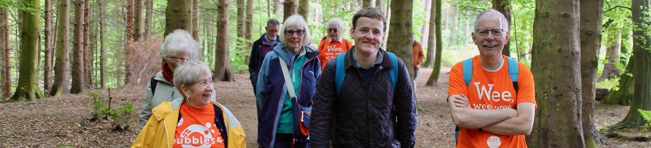 People walking through the forest wearing Fight Bladder Cancer t-shirts